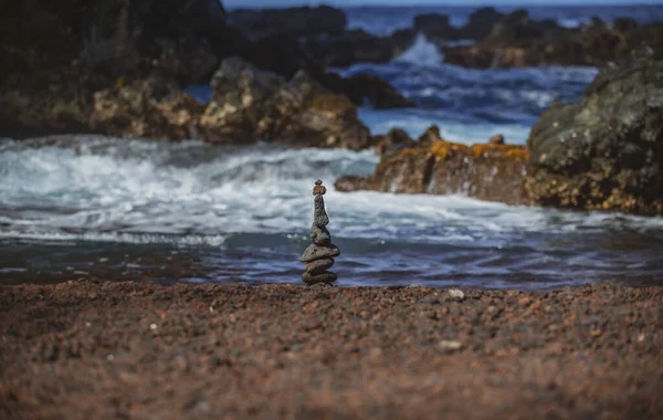 Stenar balanserar på sanden på stranden. Bakgrund från havsstenar för design. — Stockfoto