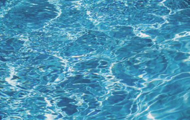 Yüzme havuzunda güneş yansımalı dalgalı su. Dalgalı su arkaplanı.