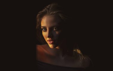 Siyah üzerine güzel bir kadın portresi. Stüdyodaki zarif kadın modelin duygusal yüzü. Zarif bir bayan. Şehvetli baştan çıkarıcı kadının yüzüne çarpıcı bir ışık..