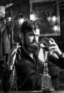 İçki içen bir adam. Alkolizm problemi ve alkol bağımlılığı kavramında araba anahtarı olan sarhoş ve akşamdan kalma sürücü..