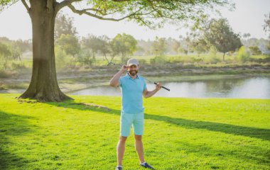 Profesyonel golf sahasında erkek golfçü. Golf sopalı bir golfçü ateş ediyor..