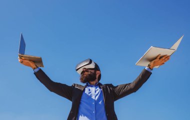 İş adamı sanal gerçekliği. Gelecekteki teknoloji konsepti. Dışarıda dizüstü bilgisayarı olan sakallı bir adam..