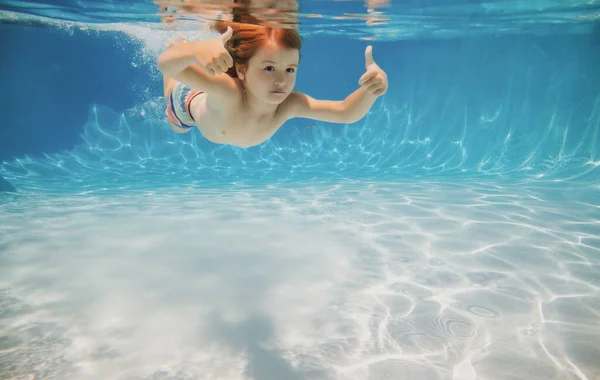 Happy kid swims in pool underwater, active kid swimming underwater, playing and having fun, Children water sport. Vacation and traveling with kids. Children play outdoors in summer water. — Fotografia de Stock