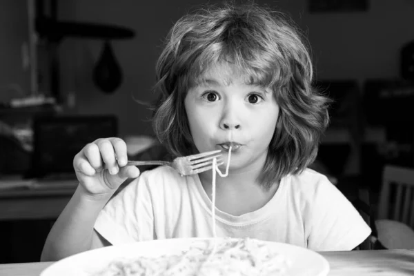 Lustigt att barn äter pasta, spaghetti. Barnens ansikte, lilla pojkens porträtt. — Stockfoto