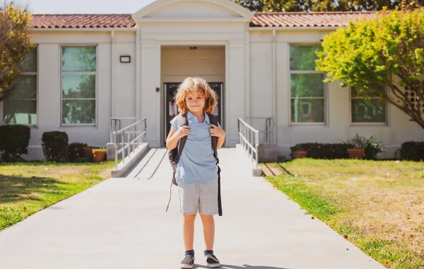 リュックを背負ったかわいい子供が走って学校に行く。学校に戻る. — ストック写真