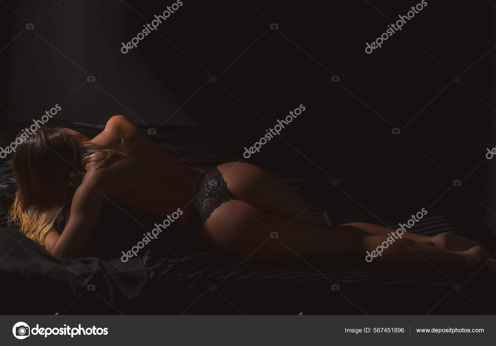 Escort service. Desire concept. Naked woman on bed. Female buttocks. Sexy ass in black lingerie. Attractive female body. Erotic massage. Perfect butt pic