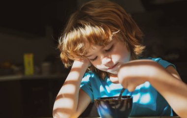 Çocuk kahvaltısını mutfakta yiyor. Çocukların beslenmesi. Çocuklar için sağlıklı yiyecekler. Organik ev yemekleri..