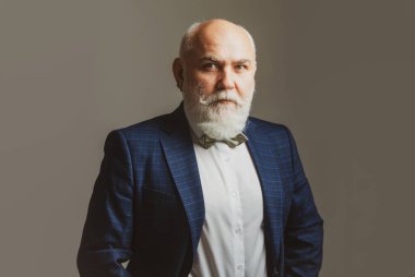 Ciddi kıdemli adam. Mutlu emeklilik. Kameraya bakan yaşlı, gülümseyen emeklinin portresini kapat..