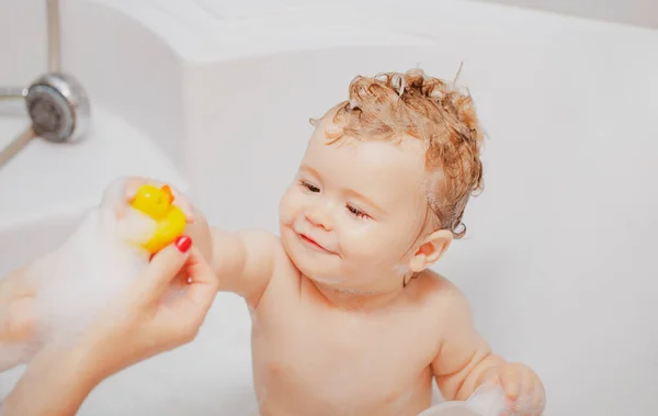 Детская ванна. Смешной ребенок купается в пене и стирается в ванной дома. — стоковое фото