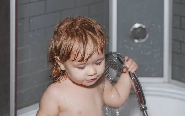 Enfant dans une baignoire. Petit bébé enfant se lave les cheveux dans le bain. — Photo