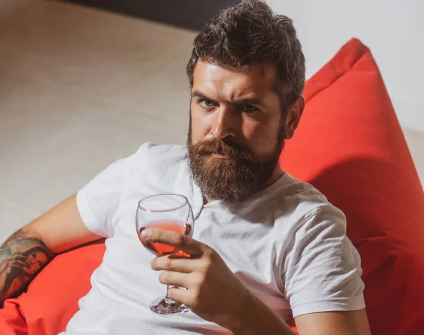 Drinking alone. Alcohol addiction. Serious man with glass of wine. Casual hipster portrait.
