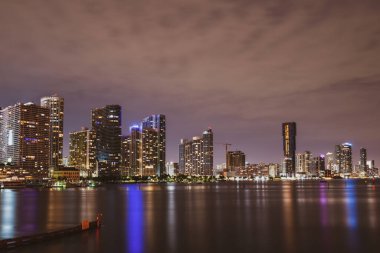 Miami Florida, günbatımı manzarası renkli iş yerleri, konut binaları ve Biscayne Körfezi 'nde köprü. Miami gecesi.