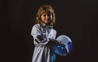 Uzay kıyafetli küçük astronot çocuk elinde siyah kaskla.