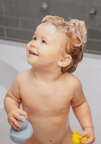 Cute funny baby boy enjoying bath and bathed in the bathroom. — Zdjęcie stockowe