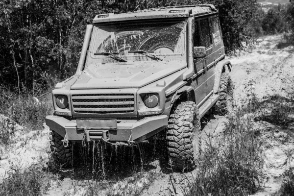 Lama e água salpicam para fora da corrida de estrada. Vestígios num campo lamacento. Viagem off-road na estrada da montanha. Trekking de viagem 4x4 . — Fotografia de Stock