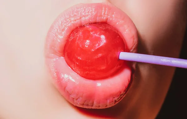 Zuigende lippen. Mond likken lolly, rode vrouwelijke glanzende lippen en roze snoep lolly. — Stockfoto