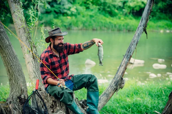 Junger bärtiger Mann angelt an einem See oder Fluss. Fliegenfischen. — Stockfoto