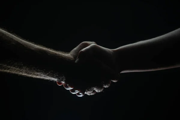 两个搭档握手，同意。男人的手被救了友好的握手，朋友的问候，友谊。救援，帮助手势或手。帮助的手. — 图库照片