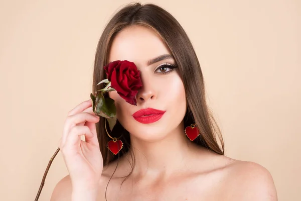 Seksowne usta kobiety z czerwoną szminką i piękną czerwoną różą. Piękna młoda piękna kobieta ze zdrową skórą i czerwoną różą w pobliżu twarzy. — Zdjęcie stockowe