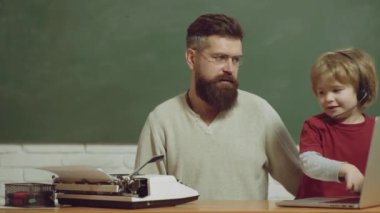 Erkek nesiller. Baba oğul gelişimi. Gençlik yaşlılığa karşı. Eski ve genç kavramları. Genç yetişkin konsepti. Baba ve çocuk eski daktilo ve dizüstü bilgisayarda yazıyor..