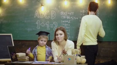 Family education. Young mother father and little preschooler boy sit at table drawing together. Schoolboy kids at elementary school.