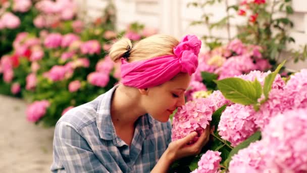 Güzel mutlu genç kadının kokusu bir çiçekli bahar bahçe — Stok video