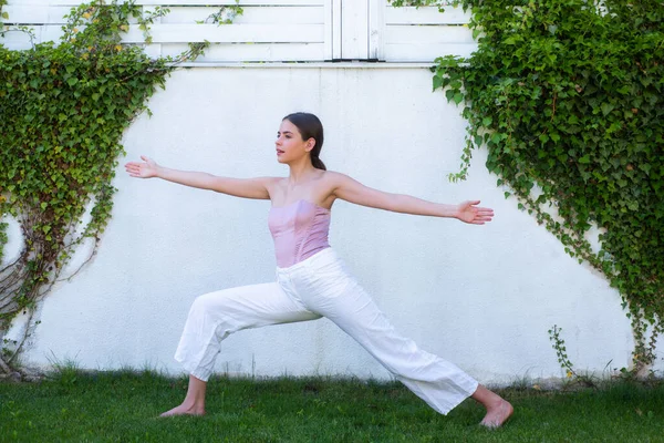 Yoga, fitness y entrenamiento. Chica en ropa deportiva haciendo yoga matutino. Mujer en forma joven estirándose. Chica joven deportiva haciendo ejercicio de fitness, la vida sana en la hierba verde. Entrenamiento al aire libre. —  Fotos de Stock