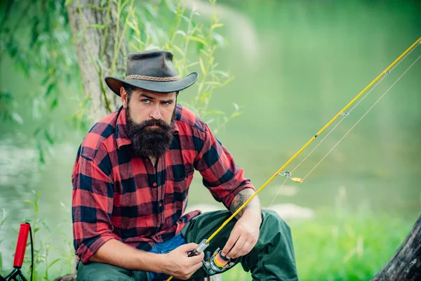 Fiskare som fiskar på en häcksax. Avslappnad fiskare man med ett metspö på en sommardag. — Stockfoto