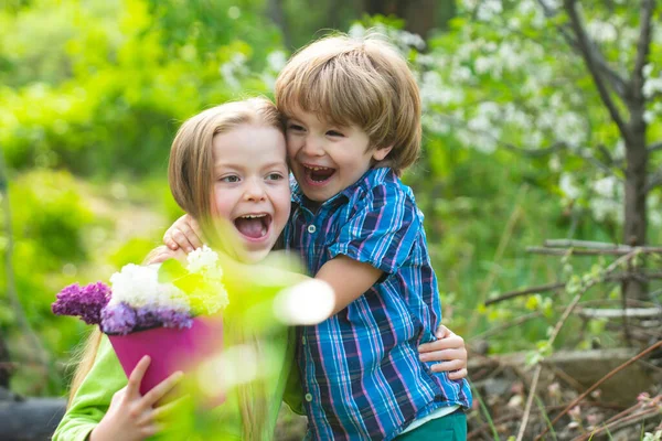 Excited little boy hugging shy girl, toddler boy embracing depressed little girl, relationship, friendship concept. Hugging kids outdoor. Excited kids in garden. — стоковое фото