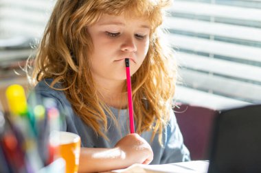 Ödev yaparken yorgun bir öğrenci. Okulun masasında yazı yazan sevimli öğrenciler var. Ev ödevi, yazı ve resim yapan sevimli çocuk. Evde kitapları olan anaokulu çocuğu..