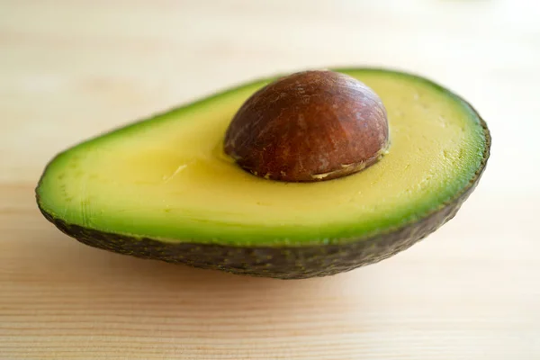 Avocado auf Holzgrund. Avocadofrucht. Rohe Früchte gesunde grüne Lebensmittel. Ganze und halbe Avocado. — Stockfoto