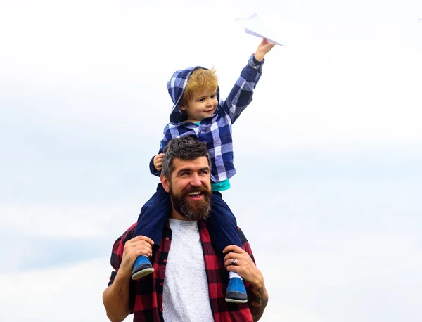 Portrait of happy father giving son piggyback ride on his shoulders. Child play with toy plane. Family travel vacation, fathers day. — Foto Stock