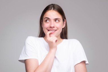 Beautiful woman with questioning gesture. Girl shrugging shoulders, doubts.