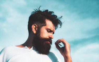 Arka planda sigara içen adam. Acımasız adam..