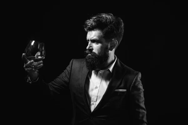Pití whisky, brandy nebo koňaku. Elegantní a stylový muž v klasickém oblečení drží sklo s klíčem v ruce. Stylový boháč držící sklenici staré whisky. — Stock fotografie