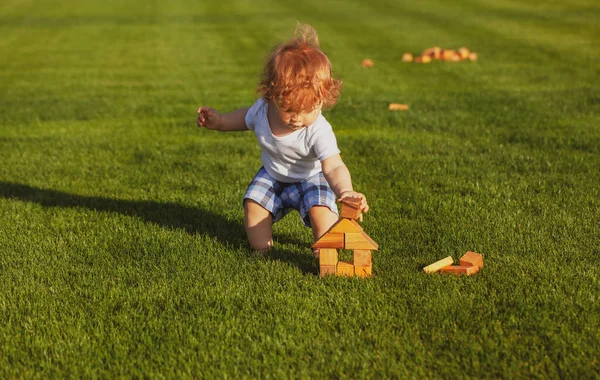 Kleine Kinder spielen im Park. Porträt eines glücklichen Babys im Gras. — Stockfoto