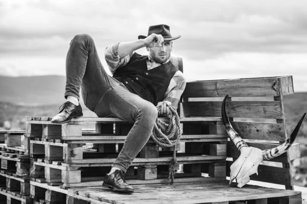 A vida ocidental. Um tipo sem barba de chapéu de cowboy e camisa de xadrez a olhar para muito longe. Homem machão barbudo bonito. Padrão de beleza dos homens. Exemplo de verdadeira masculinidade. Cowboy usando chapéu . — Fotografia de Stock