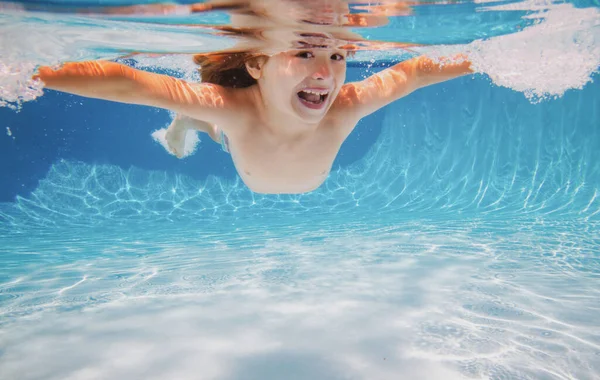 Chłopak pływa pod wodą w basenie. Pływanie dzieci i nurkowanie pod wodą w basenie wodnym. Podwodne zajęcia dla dzieci, sporty wodne. — Zdjęcie stockowe