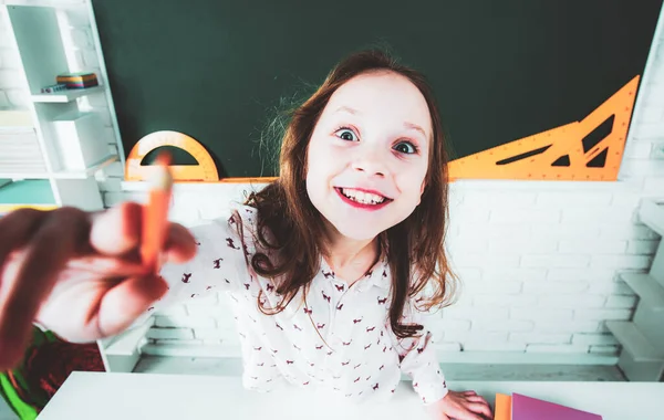 Menina engraçada em sala de aula perto de mesa de quadro-negro. O miúdo está a aprender nas aulas. Ensino pré-escolar . — Fotografia de Stock