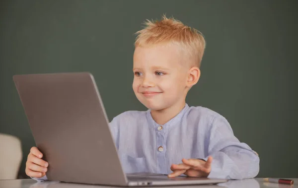 Retrato de menino alegre atraente usando laptop. Pequeno programador engraçado. — Fotografia de Stock