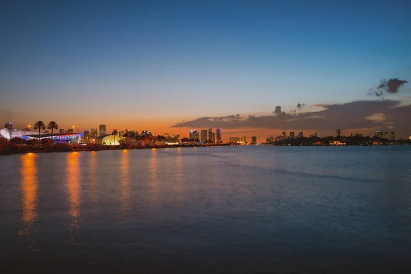 Miami, Florida városképe a Biscayne-öbölben. Panoráma alkonyatkor városi felhőkarcolók és híd a tenger felett elmélkedve. — Stock Fotó