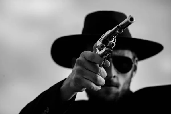 Cowboy schutter in zwart pak en cowboyhoed. Serieuze man met wilde west geweren, retro pistool revolver en marshal munitie. Amerikaanse westerse sheriff. Wilde westen gezocht concept. — Stockfoto