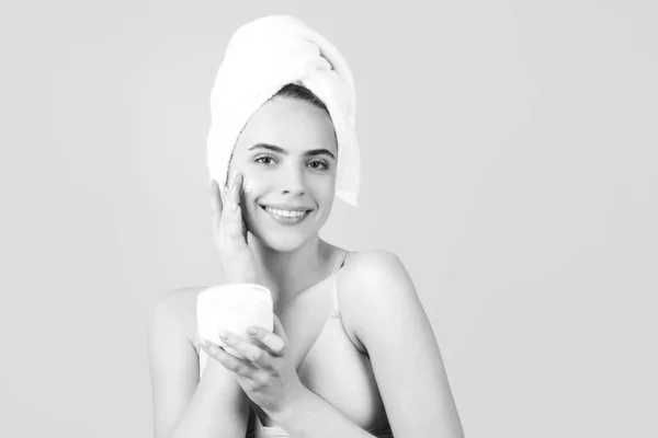Produkty kosmetyczne. Zbliżenie pięknej młodej kobiety z ręcznikiem na głowie. Piękna kobieta w studiu. Kosmetyki naturalne i pielęgnacja skóry. Piękna kobieta w salonie spa. — Zdjęcie stockowe
