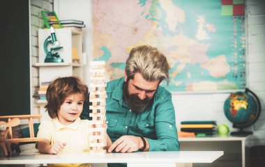 Baba ve oğul, meditasyon için Jenga oyunlarını istifliyor. Çocuk becerileri. Çocuklar konsept oynar