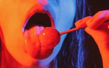 Close up lips with lollipop isolated, sexy blowjob, sensual mouth with lipstick eats sweets. Sexy design for women and girls. Beautiful lips.
