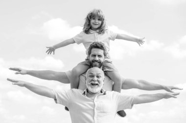 Babalar Günü. Aile babası, hafta sonları farklı yaşlarda. Büyükbabası olan baba ve oğlu el kaldırıyor ya da kollarını açıp uçuyor. Erkekler üretimi.