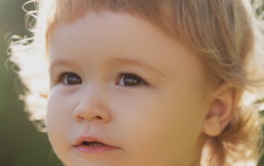 Küçük sarışın bir çocuğun portresi, yakın plan. Kesik suratlı şirin çocuklar. Pozitif duygusal Bebek.