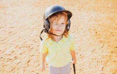 Komik çocuk beysbol oynuyor, göz kırpıyor. Gençler ligindeki vurucu vuruş yapıyor. Çocuk beyzbol topuna vuruyor..