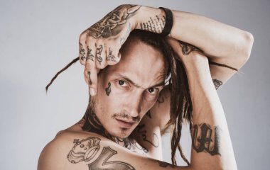 Orta parmak. Yakışıklı, dövmeli adam. Erkek dövmesi modası. Acımasız adam..