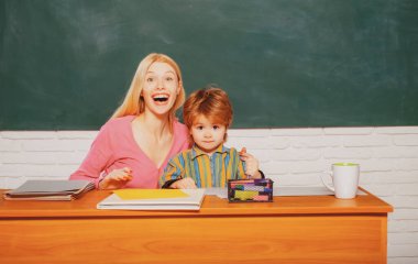 Okul çocuklarının portresi ve dersteki öğretmen. Öğretmen, genç öğrenciye derslerinde yardım ediyor..